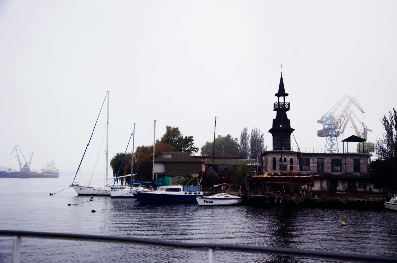 some sail boats are docked in a lake