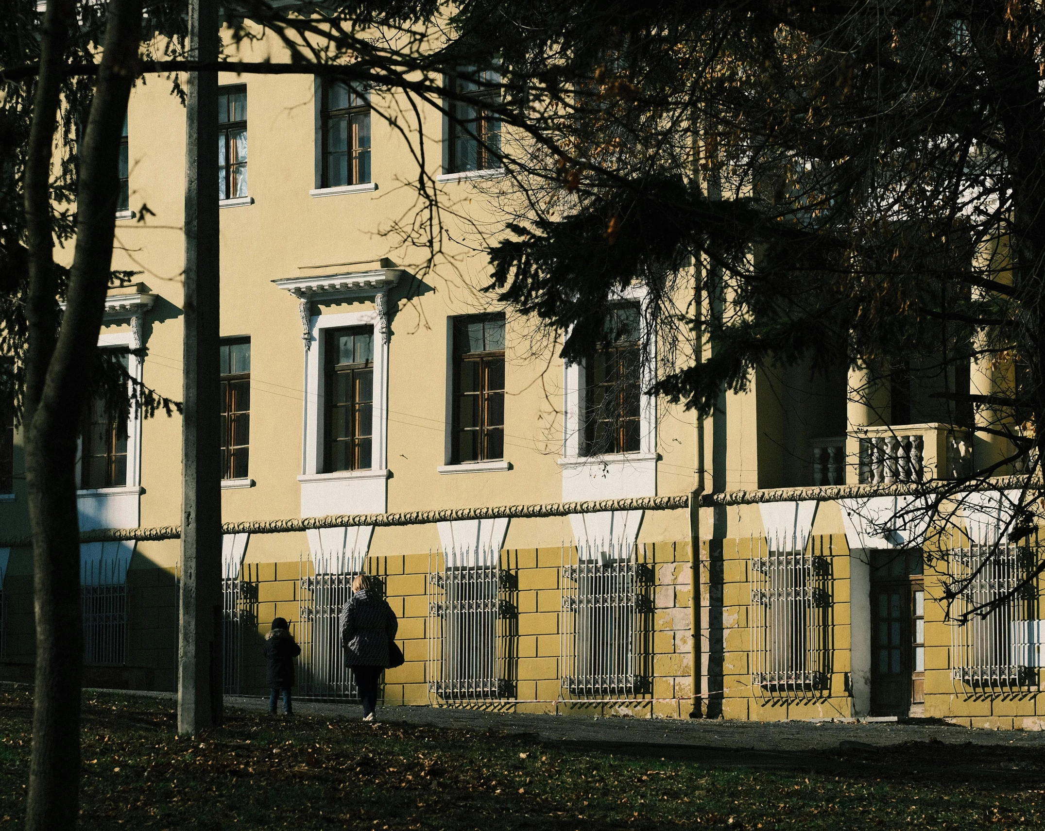 a yellow house that has two people standing in front