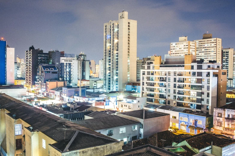 the buildings in this city at night have different lights on them