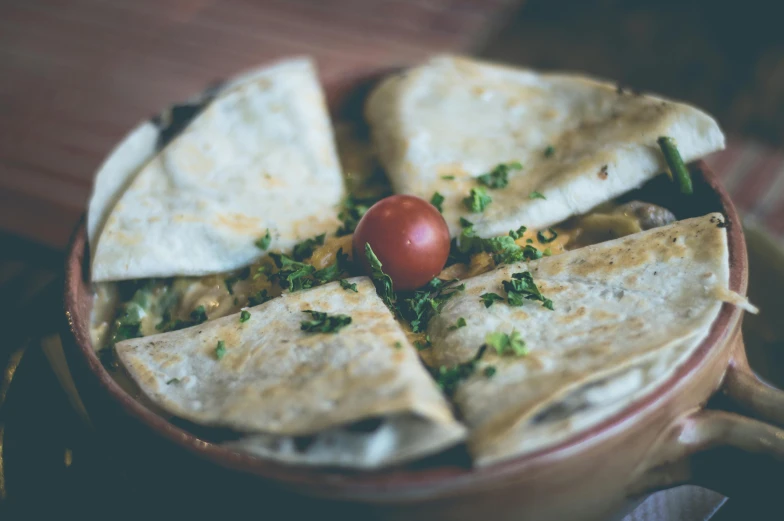 there is some tortilla and a tomato in the bowl