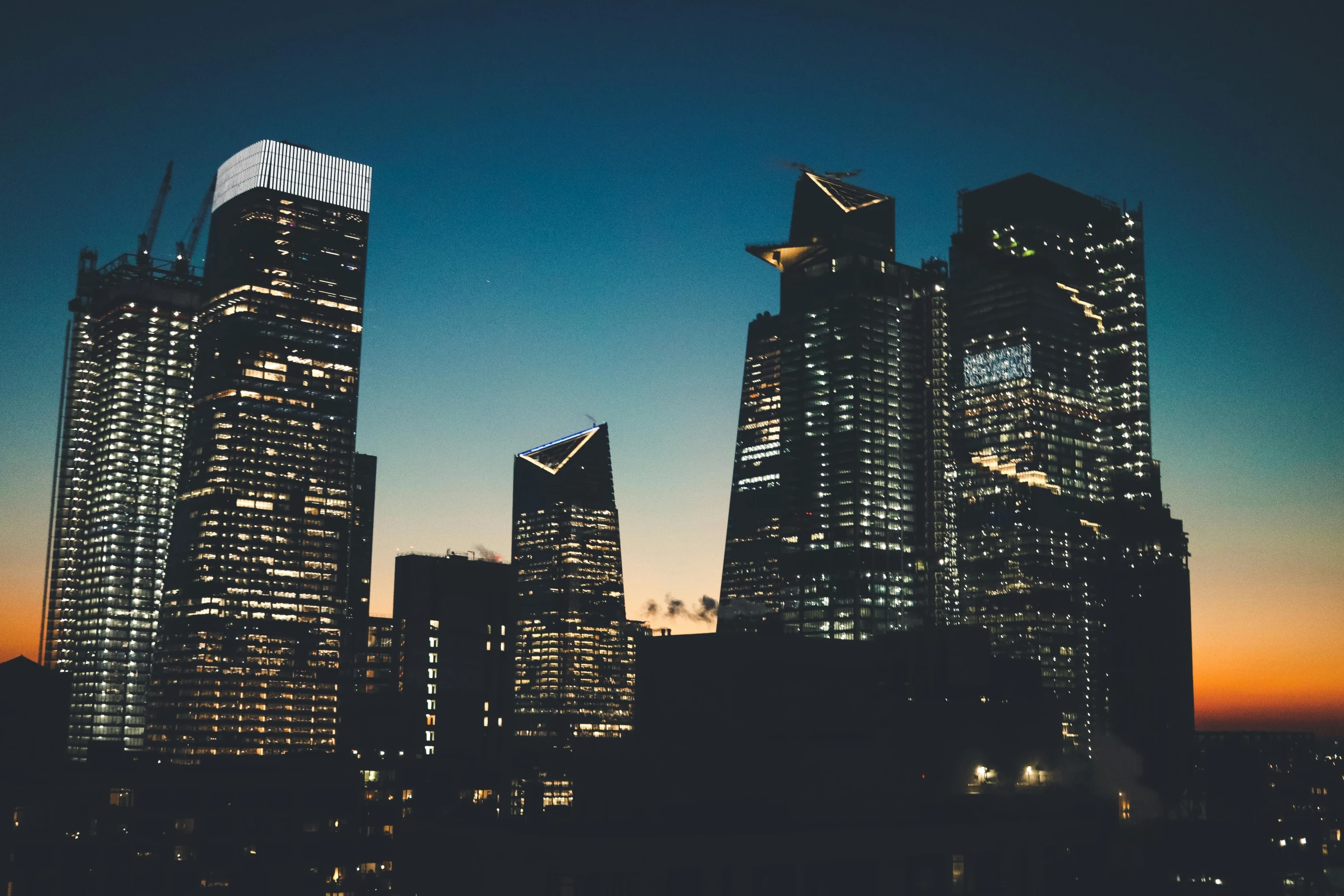 city skyline at night with buildings and skyscrs lit up