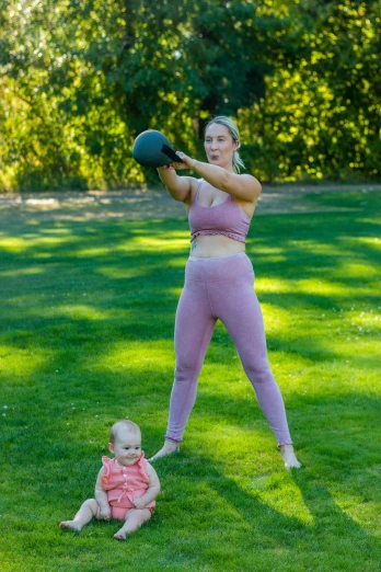 a woman and her baby are playing outside