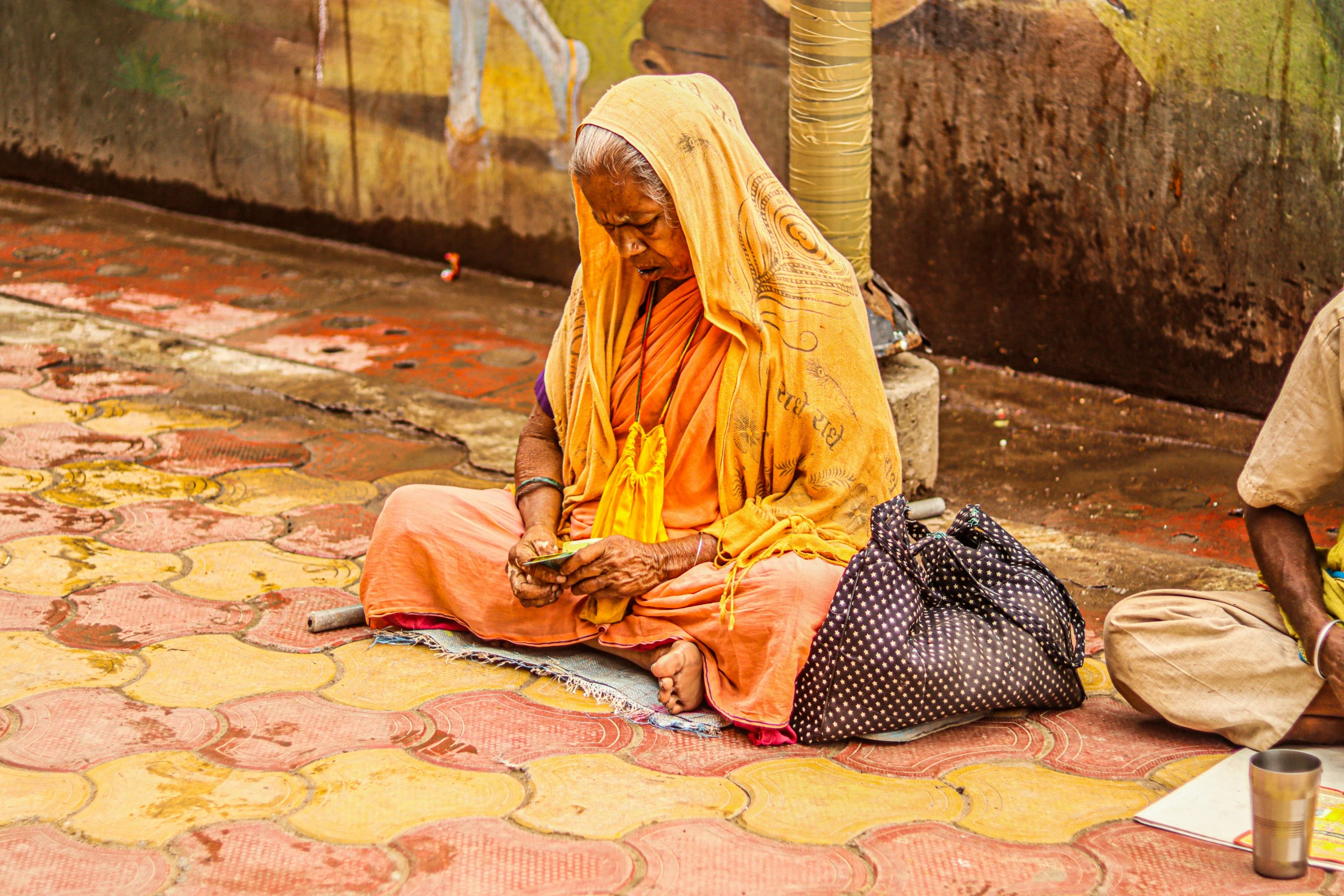 the two women are sitting down in front of a building