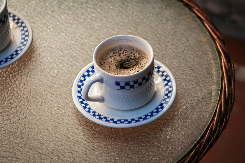 a pair of cups and saucers with liquid