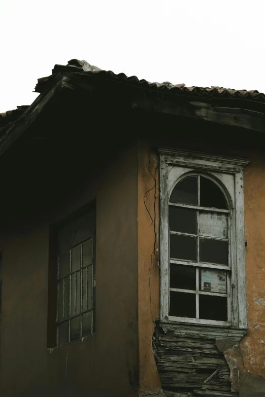 a yellow building with a window and wooden stairs