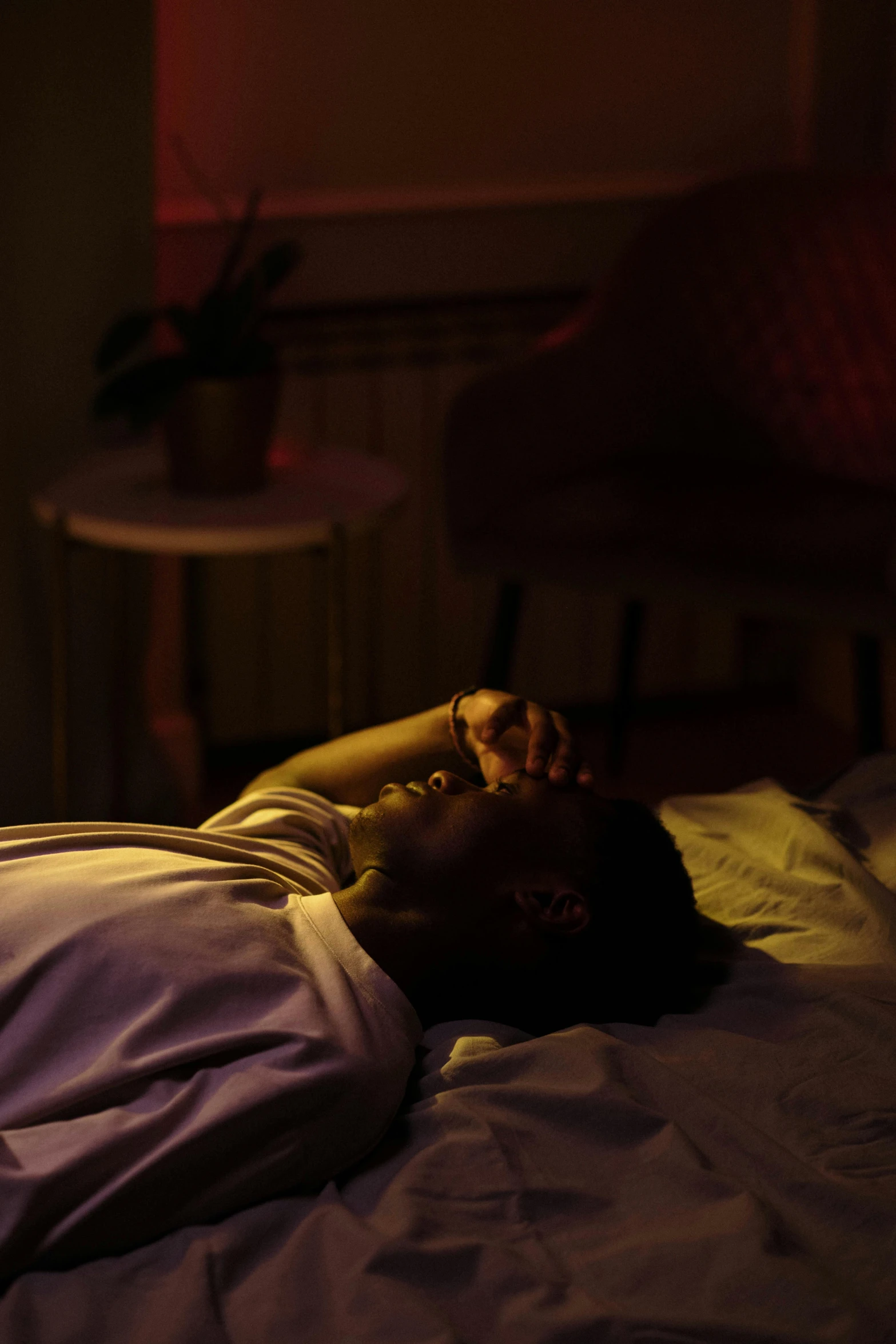 a man sleeping on a bed with the light off
