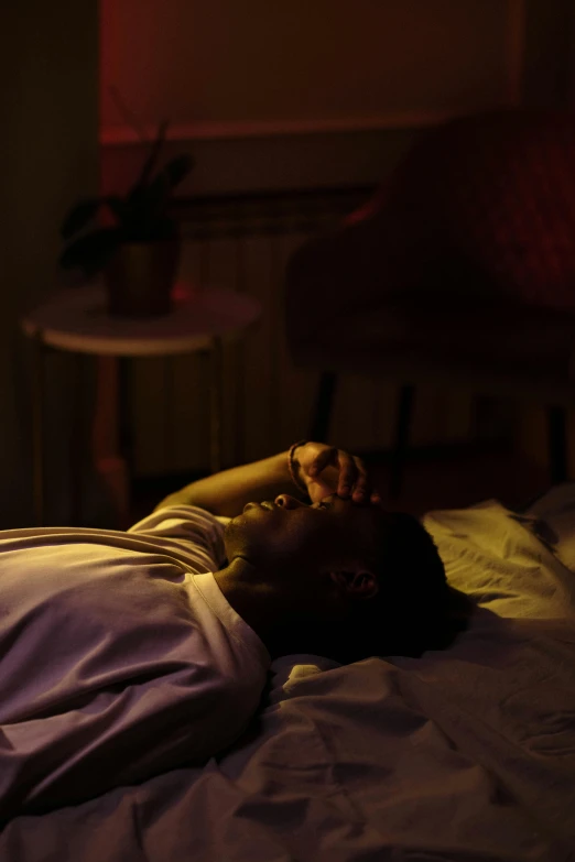 a man sleeping on a bed with the light off