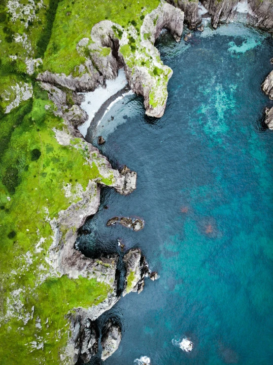 an aerial view of the blue water surrounded by rocks