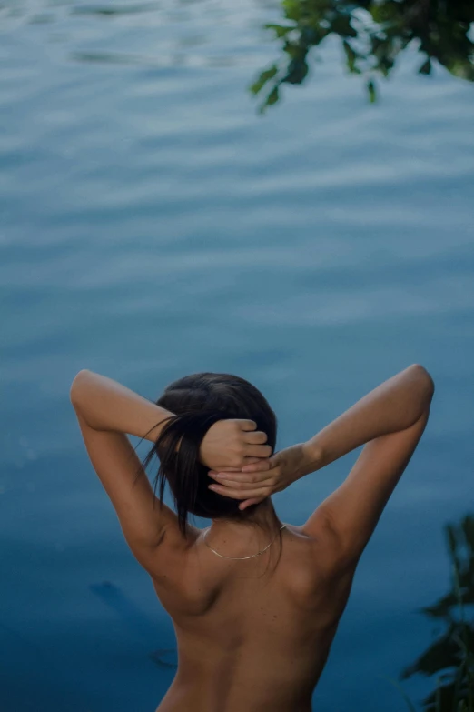 the woman is  and standing outside by the water