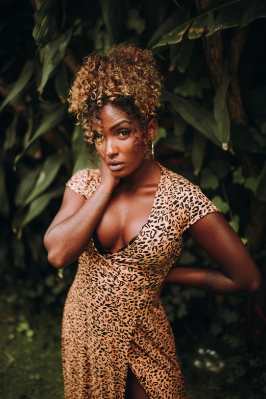 a woman with short hair standing in front of plants