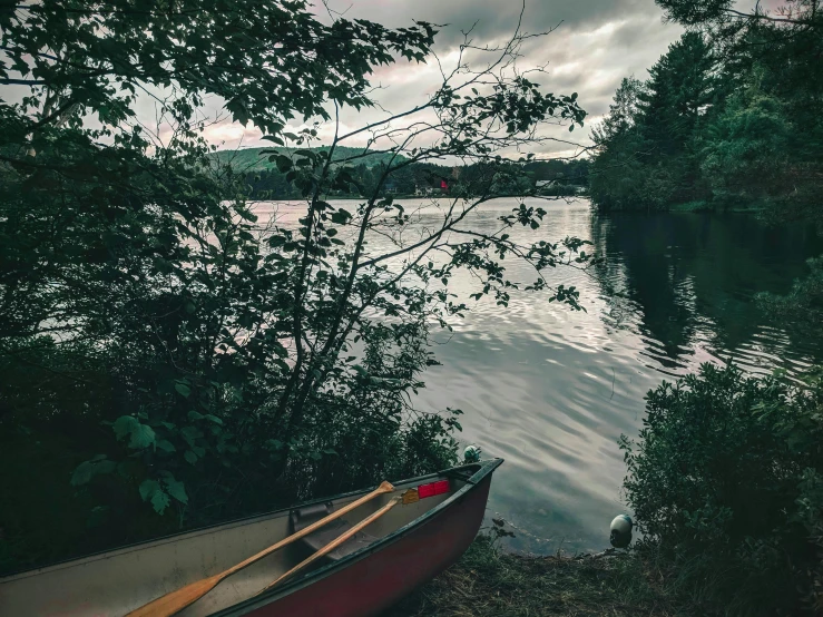 canoe next to a small boat on the edge of water