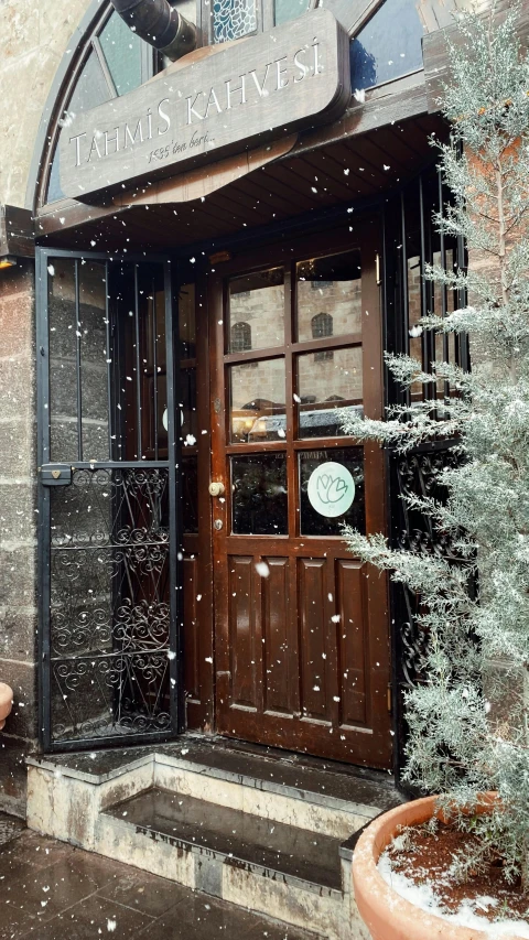 a restaurant with wooden door surrounded by snow
