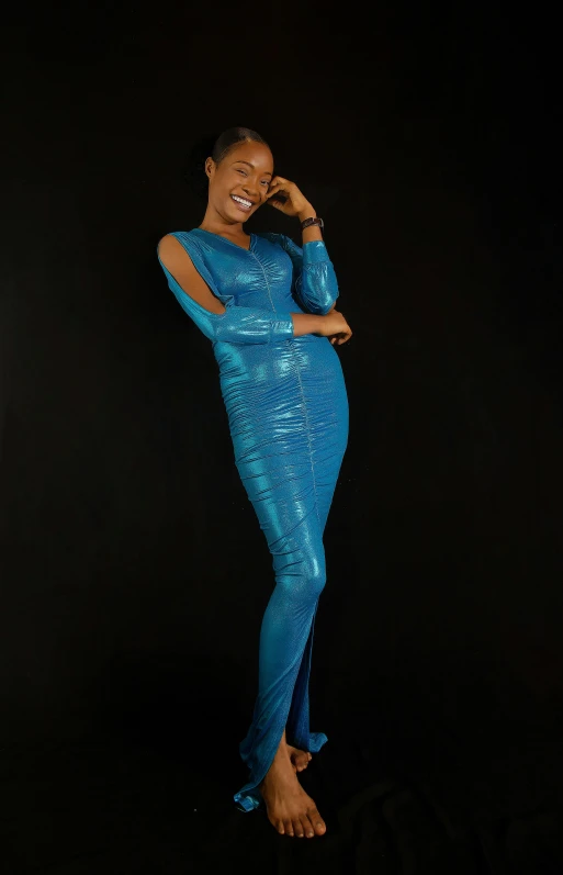 a woman in a blue gown standing with her hands on her face