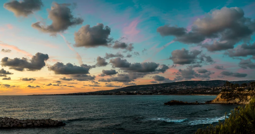 clouds are gathering above the ocean and mountain