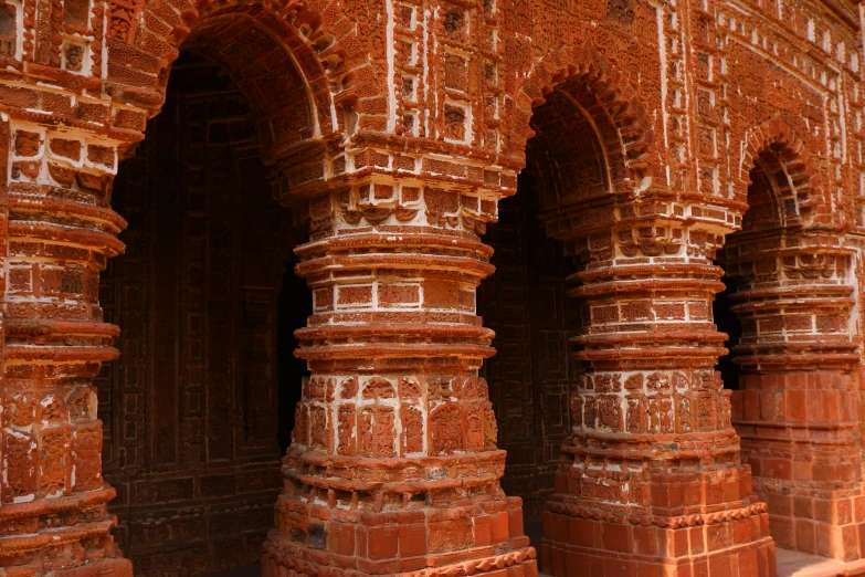 an orange and brown brick building with three arches