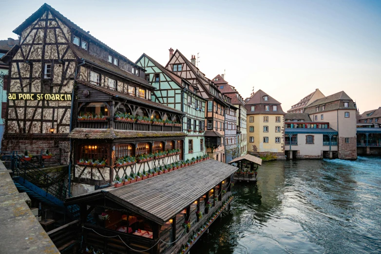 several buildings next to a body of water at sunset