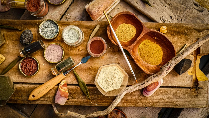 three bowls containing spices are set on top of a wooden table