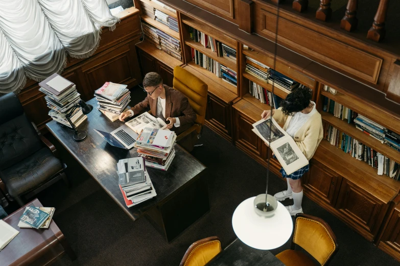 a lady standing by some books in a liry