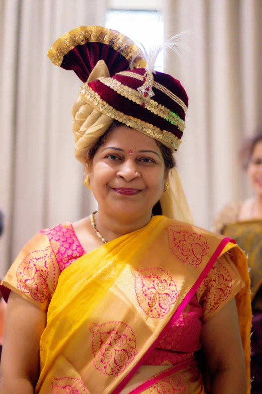 the woman is wearing a fancy yellow sari