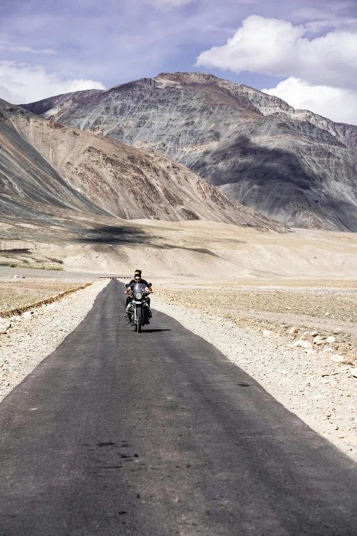 the man rides a motorbike through an empty mountainous area