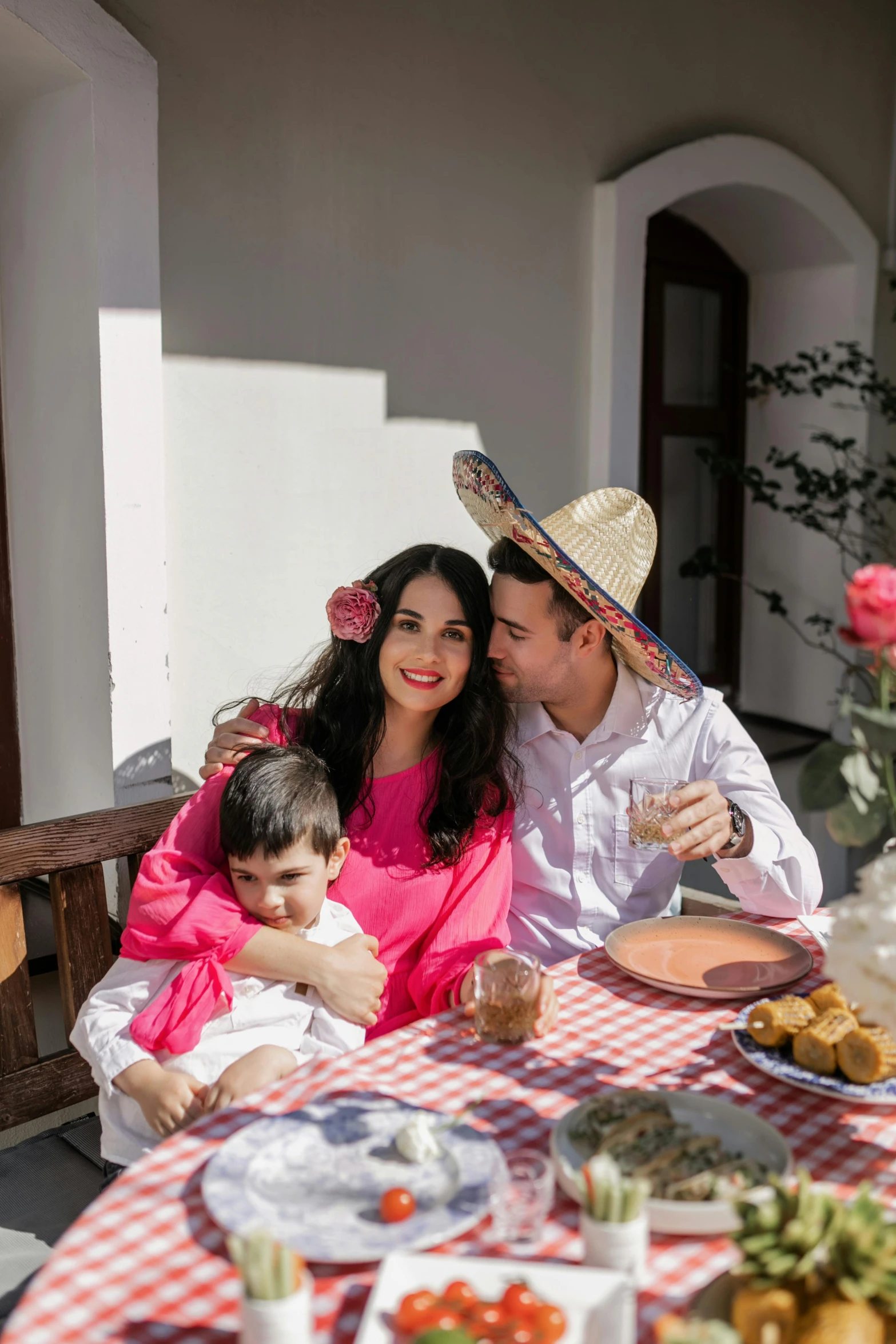 a man and woman are smiling while sitting at a table with a baby