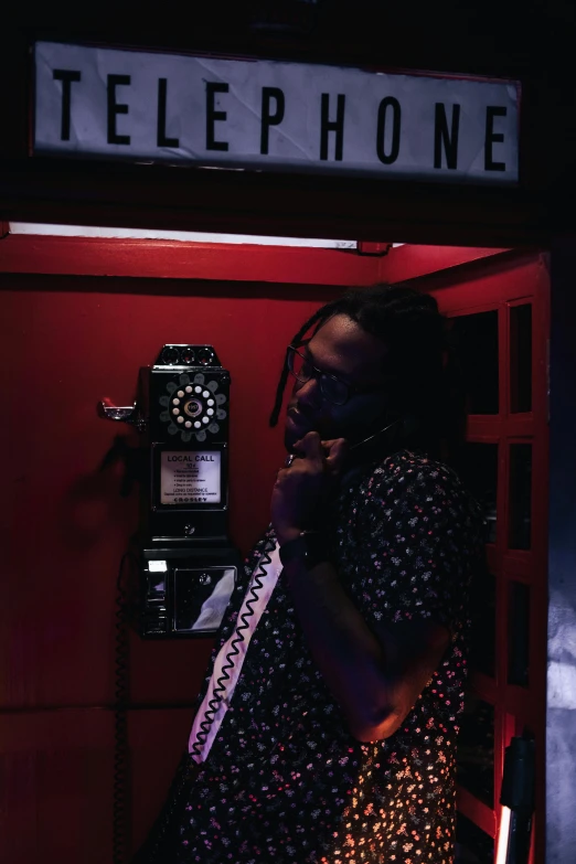 a woman is in the phone booth talking on the phone
