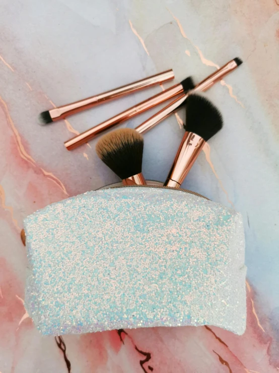 make - up brush and makeup bag on marble surface