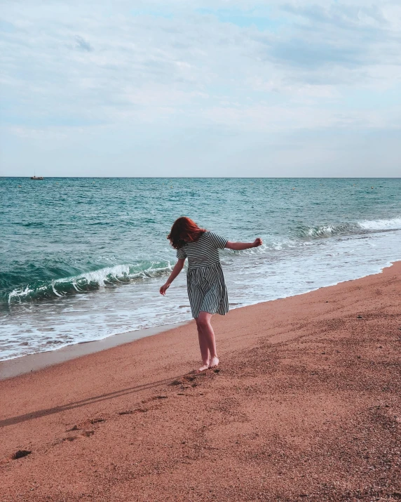 a woman standing on a beach with a frisbee