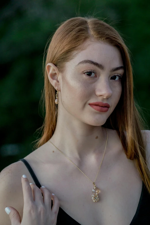 a girl in black shirt and earrings posing