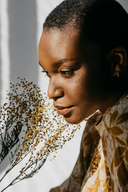 a woman holding a bunch of dead flowers