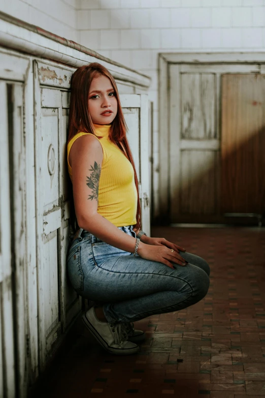 the young woman has her leg crossed and her yellow shirt is open