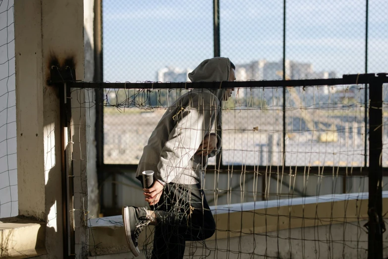 a person with a backpack leaning on a fence