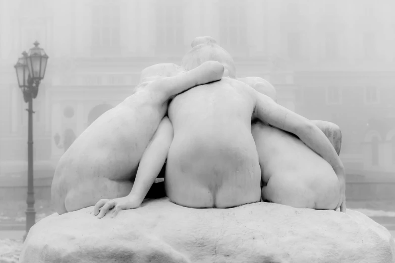 a black and white po of two women hugging on top of a rock