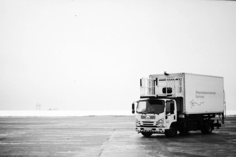 a delivery truck sits in the middle of a parking lot