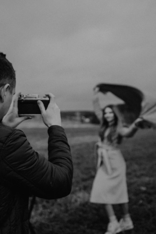 a man and woman with their cell phones taking pictures