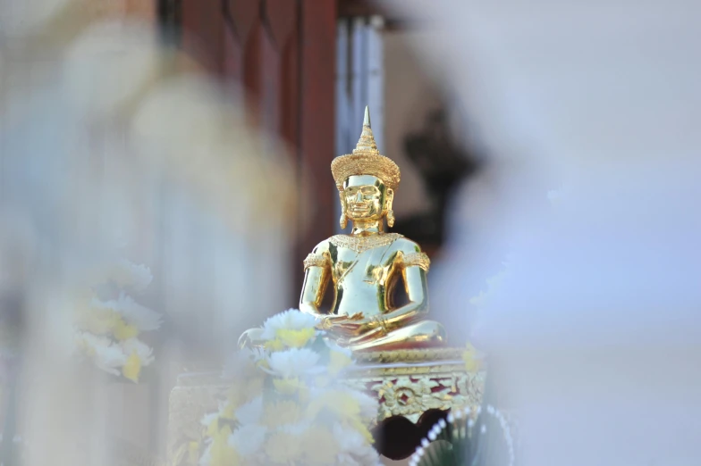 a statue sitting next to the side of a wall