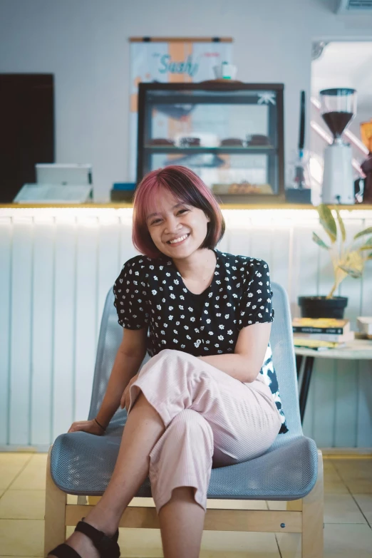 a woman is sitting on the counter smiling