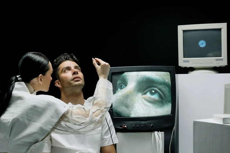 two people looking at a television screen