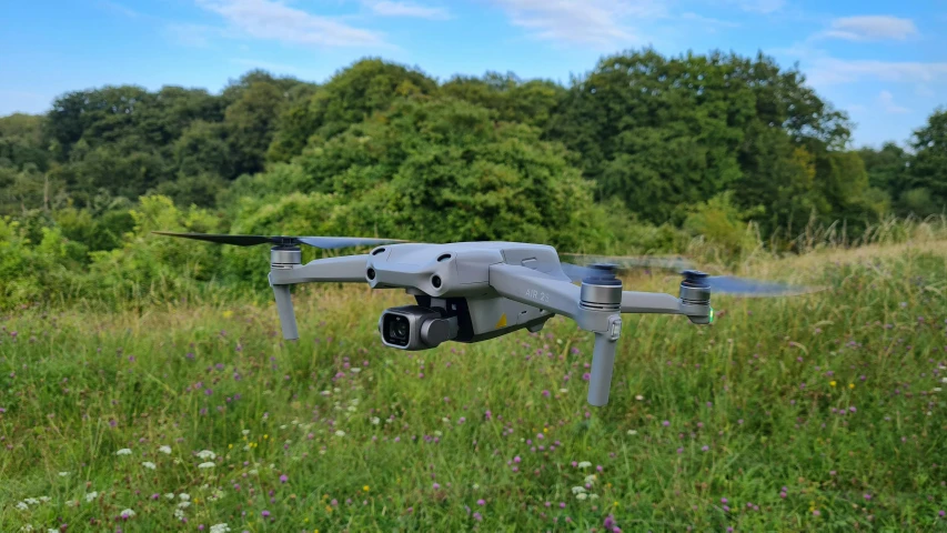 the small grey aircraft is flying over the grass