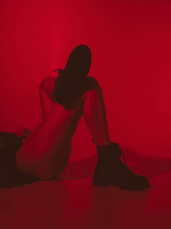 a woman sitting on the floor in a dimly lit room