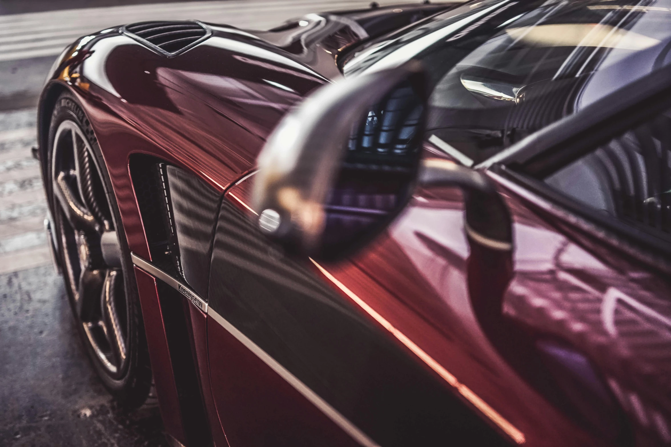 the reflection of two cars in the side mirror of another car