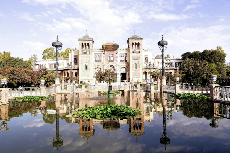 large castle building with towers next to water in the middle of town