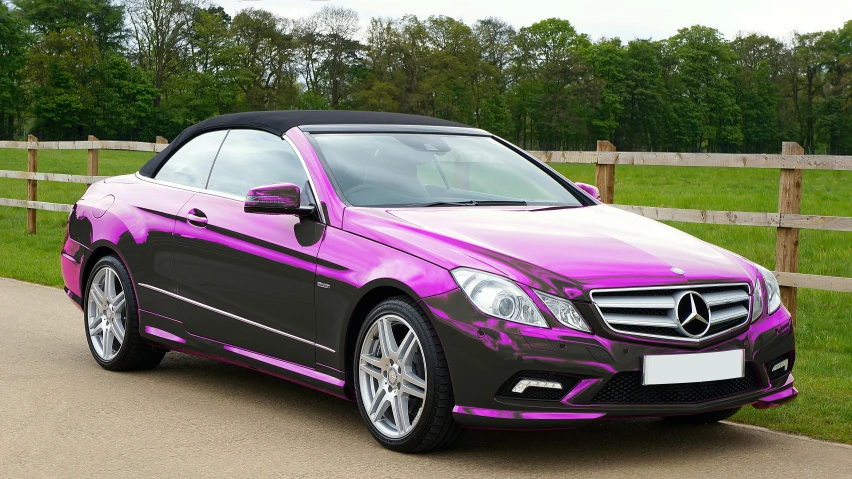 the front end of a pink and black mercedes