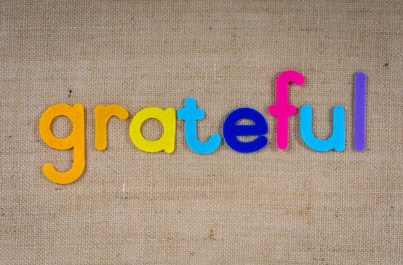 the word grateful made with colored alphabet letters on a canvas background