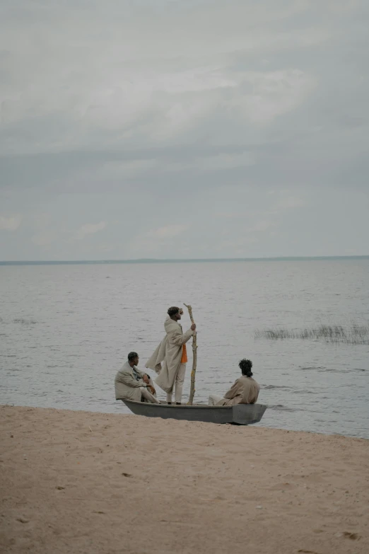 two people sitting on a boat at the beach