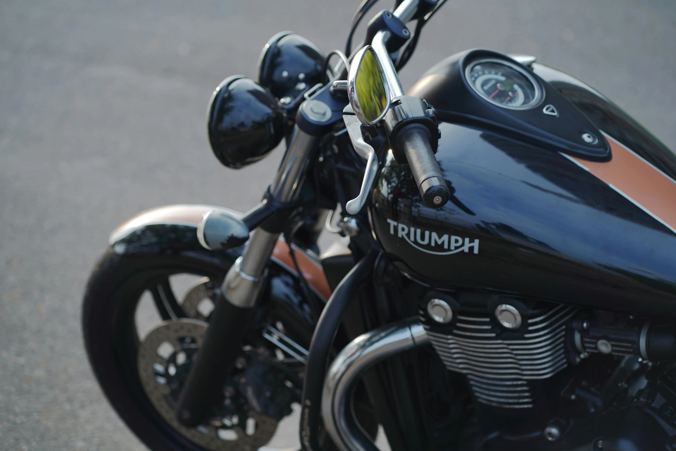 a close - up of a triumph motorcycle parked on the street