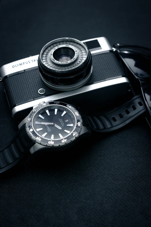 a watch and sunglasses on top of a black table