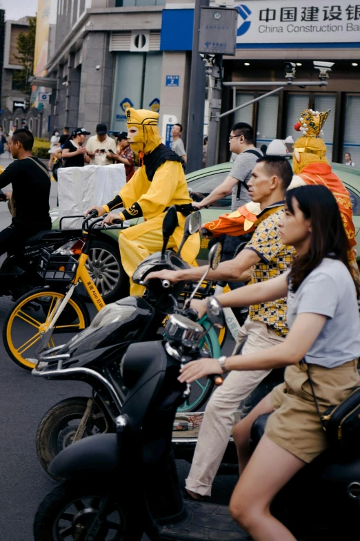 several people wearing yellow costume on motorcycles in a city