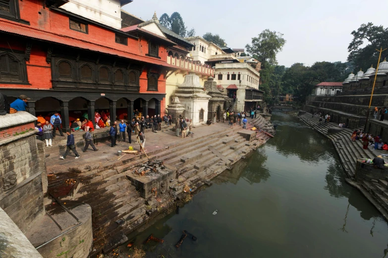 people standing around looking over a bridge at a river