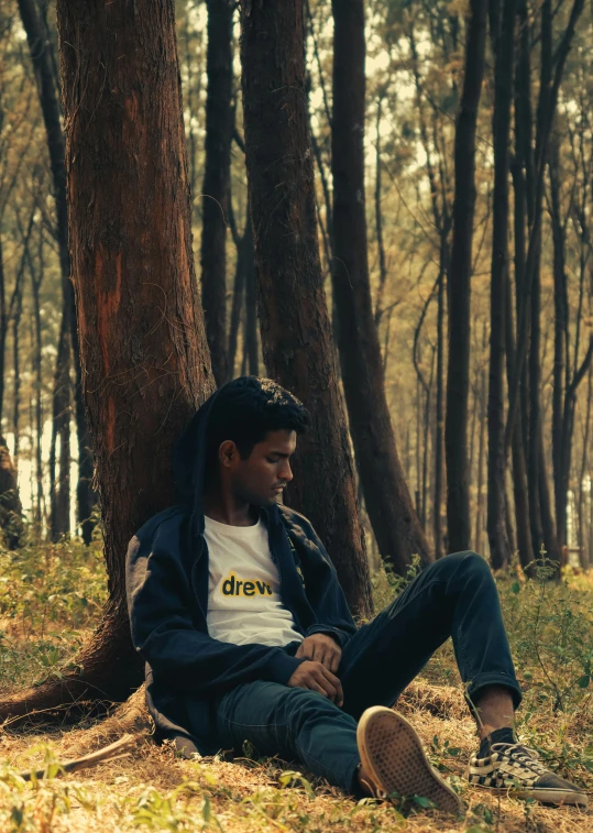 a person sitting in the grass near trees